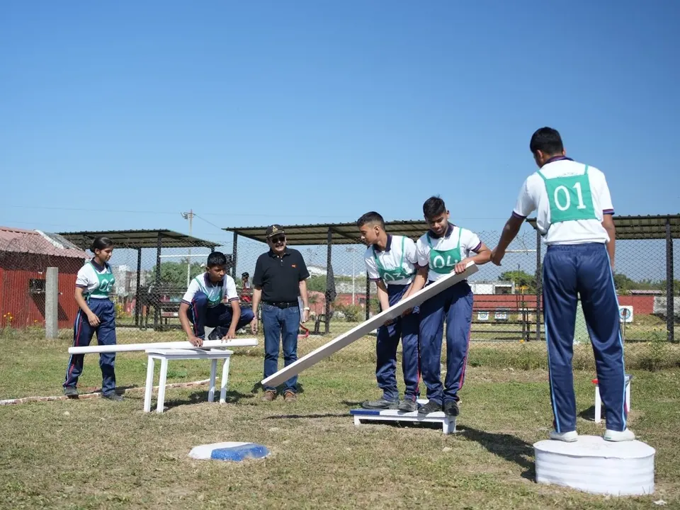 A team of students works out how to move a plank across an obstacle