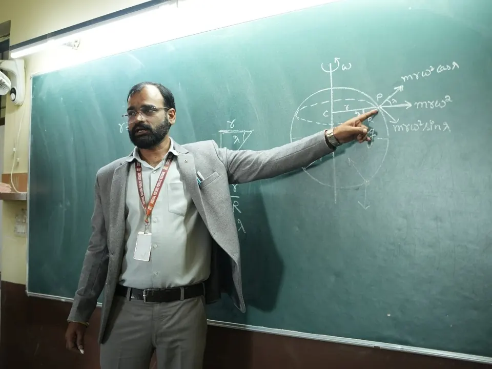 A teacher explains a mathematics problem on the blackboard