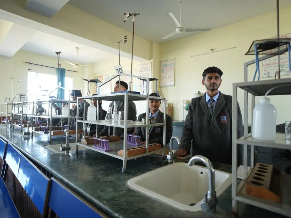 A student stands at a bench in a science laboratory